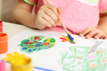 Naklejka premium Child's hand painting colorful artwork with paintbrush and bright paints on white paper, creative development and early childhood education