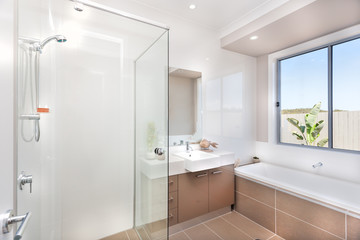 Fototapeta na wymiar Modern bathroom with a faucet, water tub and a dark brown floor