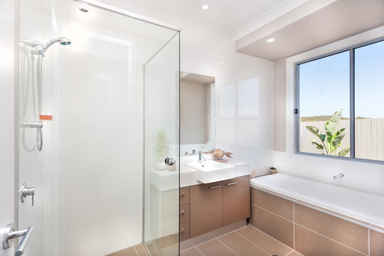 Modern bathroom with a faucet, water tub and a dark brown floor