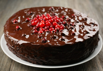 Chocolate cake with cranberries on wooden table, closeup