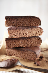 Pieces of frosting chocolate cake on parchment paper