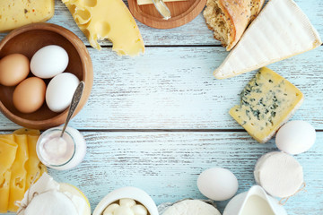 Fototapeta na wymiar Frame of fresh dairy products on blue wooden table