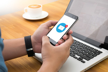 young man working from home using smart phone, email icon