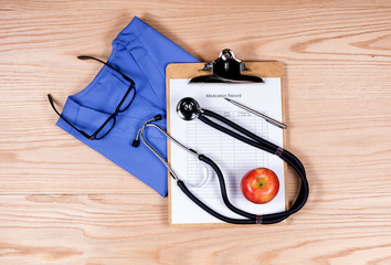 Medical clothing and equipment on wooden desktop