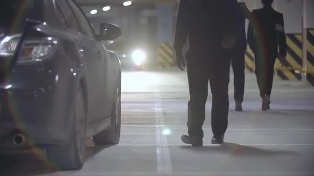 Criminals sitting in the car with body of victim hidden in trunk and leaving underground parking