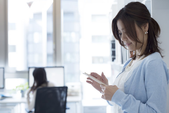 Women are using a smart phone in the office