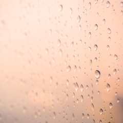 Rain drop on glass background with warm filter