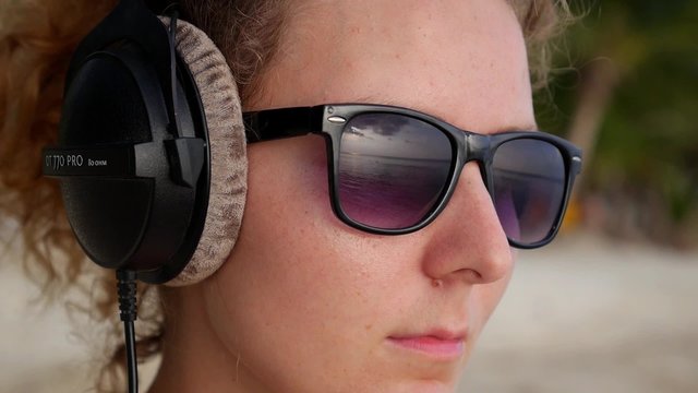 THAILAND, DECEMBER, 2014 - Closeup Young Woman with Big Headphones near the Sea.