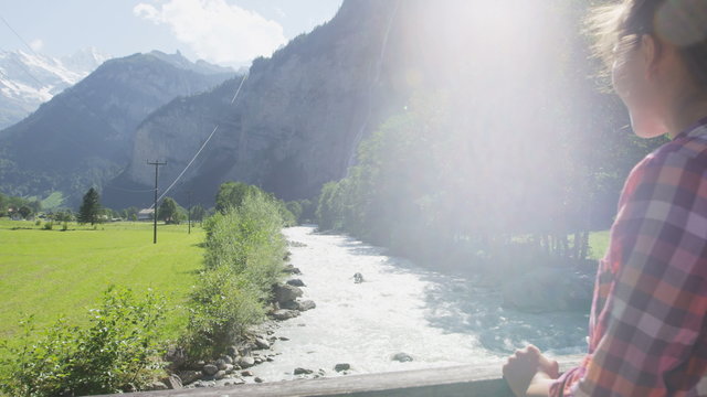Switzerland nature Swiss Alps landscape with river Weisse Lutschine. Woman hiker hiking in alpine Lauterbrunnen valley. Jungfrau, Eiger, Monch mountains in background in Bernese Oberland, Schweiz.