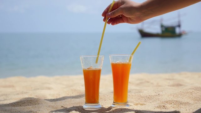 Two Glasses of Orange Juice on a Beach on Vacation