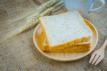 whole wheat bread in wooden bowl and cup