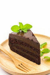 Chocolate cake slice in wooden plate.