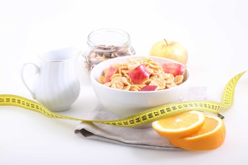 Muesli with Apple slices, an orange and the measuring tape, a us