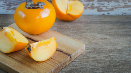 Delicious orange persimmons on wooden table