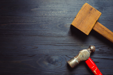 Fototapeta na wymiar wooden and still hammer on black wooden background