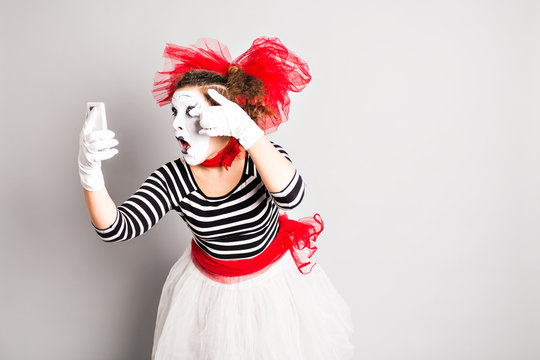 April Fool's Day concept.  Mime holding cell phone. 
