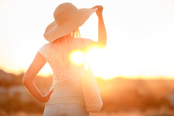 Woman in hat with large fields, at sunset
