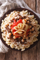Egyptian Cuisine: kushari close-up on the plate. Vertical top view
