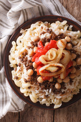 kushari of rice, pasta, chickpeas and lentils close up. vertical top view

