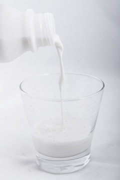 Pouring fresh milk into glass