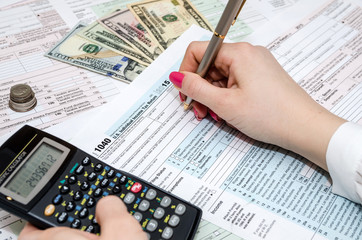 Fototapeta premium woman hand filling in individual return tax form
