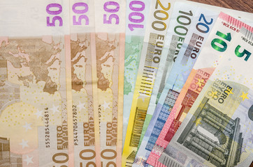 various euro notes on wooden table