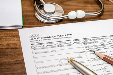 health insurance claim form and stethoscope