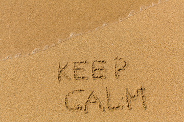 Keep calm - text written on sandy beach with the soft wave.