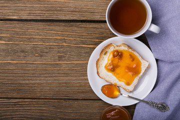 Bread with butter, apricot jam and a Cup of black tea
