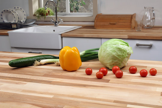 Fresh vegetables on wooden kitchen countertop. Preparing ingredients for fresh healthy salad. 