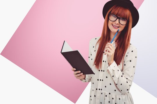 Composite image of attractive hipster woman writing on notepad