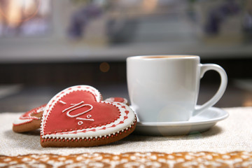Celebration of love. Closeup of a cup of warm beverage served with Valentine’s day decorated heart shaped cookies