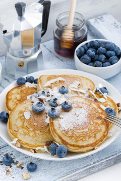 homemade pancakes with blueberries, honey and powdered sugar