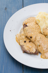 fried meat with sauce and mashed potato on white plate