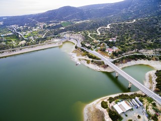 Aerial view of the earthfill dam (aka Embankment Dam) in Yermasoyia,Limassol,Cyprus. The bridge leading to the mountains, the water reservoir, artificial lake and the nature trails in Germasogia area.