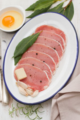 raw pork on dish with herbs,garlic and egg