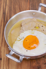 fried meat with sauce and fried egg in dish