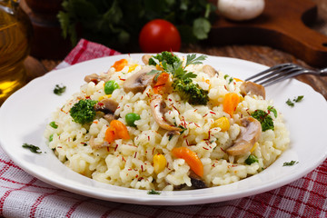 Fototapeta na wymiar Classic Risotto with mushrooms and vegetables served on a white