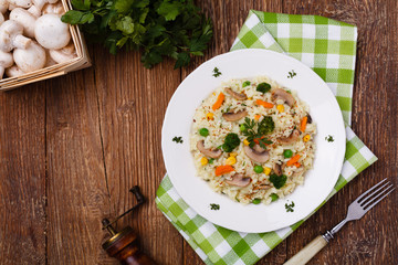 Classic Risotto with mushrooms and vegetables served on a white