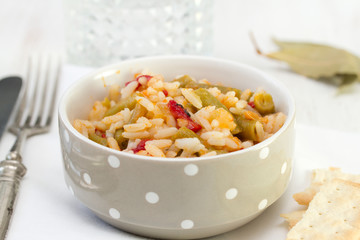 rice with vegetables in white bowl and glass of water
