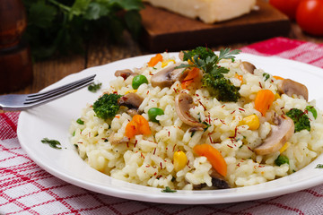 Classic Risotto with mushrooms and vegetables served on a white