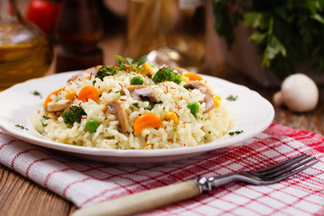 Classic Risotto with mushrooms and vegetables served on a white © gkrphoto