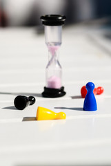 colored chips and hourglass on a white wooden table
