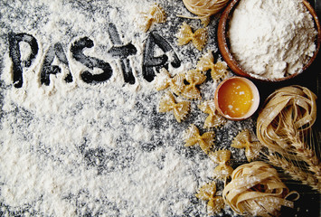 Uncooked pasta with flour on the table, selective focus