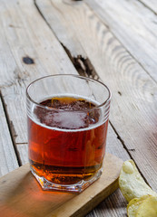 one glass of dark beer with potato chips on a wooden plank background Aged tree top view