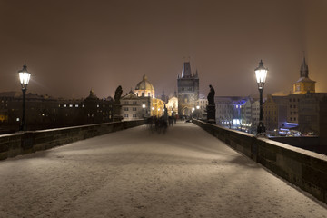 Fototapeta na wymiar Night romantic snowy Prague Old Town from Charles Bridge with its baroque Sculptures, Czech republic