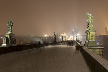 Night romantic snowy Prague Old Town from Charles Bridge with its baroque Sculptures, Czech republic