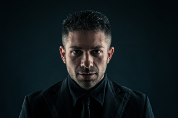 Fiery man close up portrait against dark background.