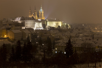 Night snowy foggy Prague City with gothic Castle, Czech republic