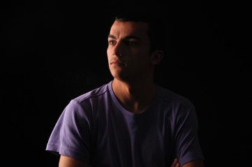Fototapeta premium Portrait of young man wearing t-shirt standing with hands in poc